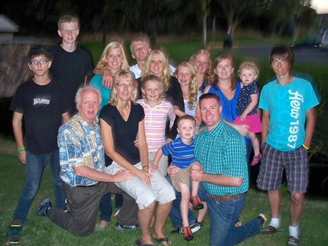 Photo from the 2012 Christmas letter: a large family group posed together on the grass at dusk