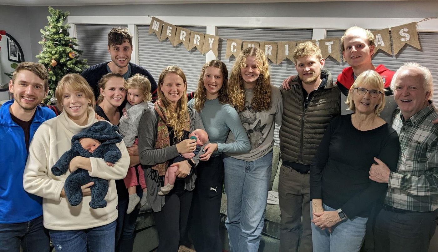 Photo from the 2022 Christmas letter: the King family gathered indoors under a decorated banner